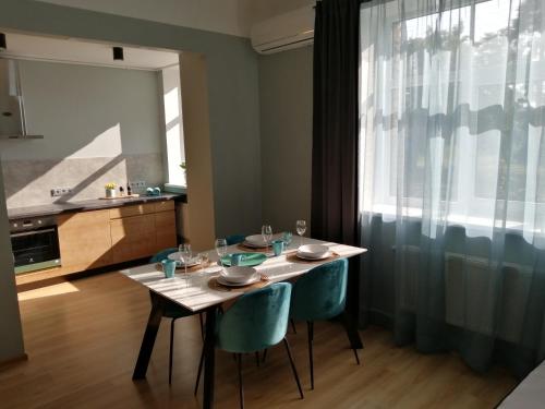 a dining room with a table and chairs and a kitchen at Bauskas Street Apartments in Rīga