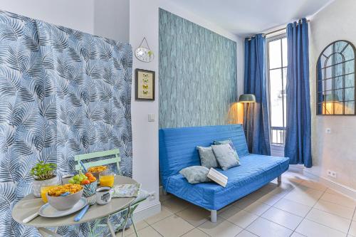 un canapé bleu dans un salon avec une table dans l'établissement MY CASA - GROSSO 14, à Nice