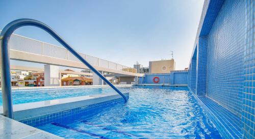 a swimming pool with a fence and blue water at Mainake Costa del Sol in Torre del Mar
