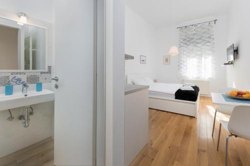 Un baño blanco con una cama y un lavabo. en Modern Apartments near park Zrinjevac, en Zagreb