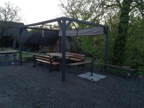 a picnic shelter with a picnic table and benches at Ekofarma Rytířova Lhota in Rytířova Lhota