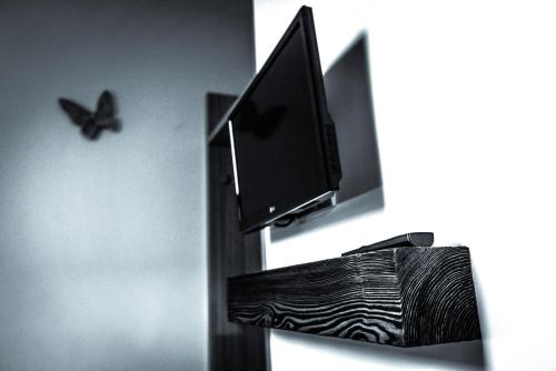a butterfly is standing next to a television on a wall at Penzion Víno Hruška in Veselí nad Moravou