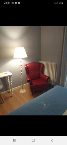 a bedroom with a red chair and a lamp at Boutique Hotel Palazzo Corso Umberto in Boiano