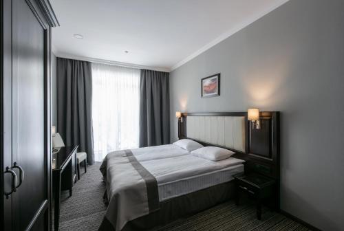 Ένα ή περισσότερα κρεβάτια σε δωμάτιο στο Optima Collection Park Hotel Ivano-Frankivsk