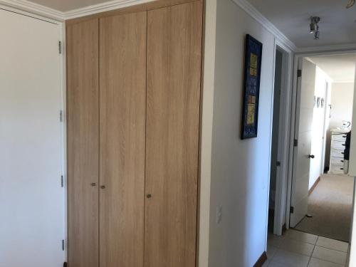 a hallway with a wooden cabinet in a room at Papudo Laguna Apartment in Papudo