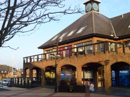 a building with a clock tower on top of it at Boathouse Hotel in Hythe