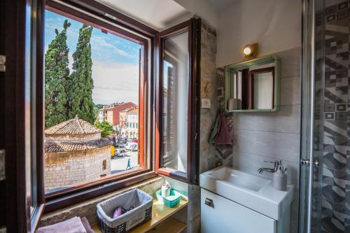 un bagno con lavandino e finestra di Studio apartment Lux a Rovigno (Rovinj)