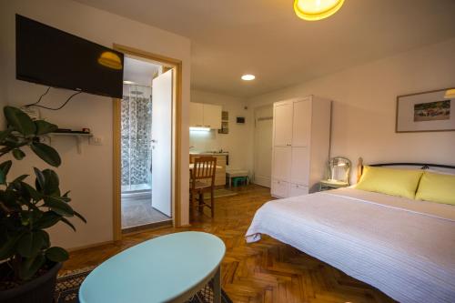 una camera da letto con un letto, un tavolo e una cucina di Studio apartment Lux a Rovigno (Rovinj)