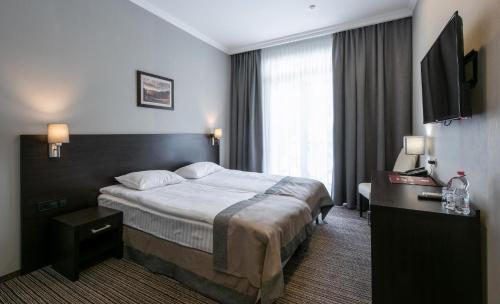 Ένα ή περισσότερα κρεβάτια σε δωμάτιο στο Optima Collection Park Hotel Ivano-Frankivsk