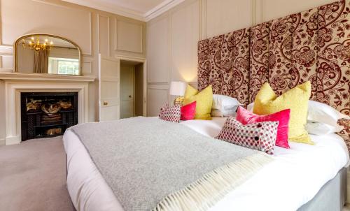 a large bedroom with a large bed with colorful pillows at Trewornan Manor in Wadebridge