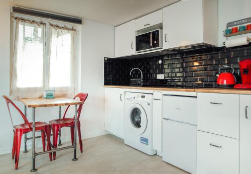 a kitchen with a washing machine and a table and chairs at Studio Le Perreux proche Paris et Disneyland in Le Perreux-Sur-Marne