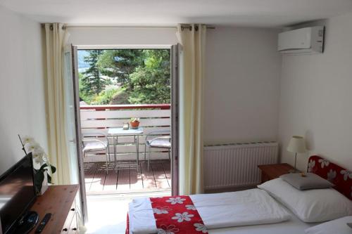 a bedroom with a bed and a balcony with a table at Gästezimmer Rolea in Dürnstein