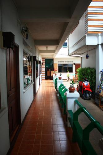 清邁的住宿－โรงแรมตีฆ้อง - Tri Gong Hotel，一条带绿桌和摩托车的餐厅走廊