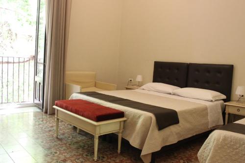 a bedroom with a large bed and a large window at Umberto House Catania in Catania