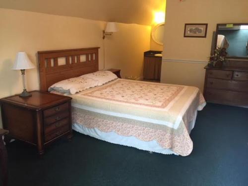 a bedroom with a bed and a dresser and a night stand at Big South Fork Trail Lodge in Stearns