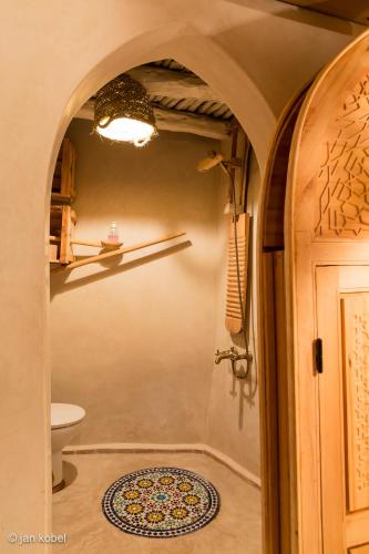a bathroom with a shower and a toilet and a door at Dar KamalChaoui in Bhalil