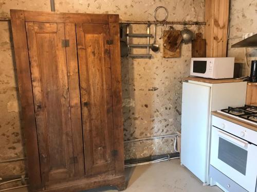 a kitchen with a wooden cabinet next to a stove at Côte du Jardin in Pouillé