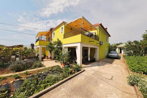 a yellow house with a car parked in front of it at Senkini Dvori in Sutomišćica