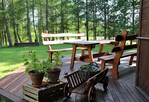 a wooden deck with a picnic table and a bench at Pod Dębem in Giby