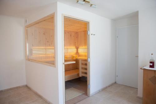 a small room with a wooden door and a white refrigerator at Gasthof zum Goldenen Anker in Hainburg an der Donau