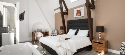 a bedroom with a large bed and a bath tub at Gasterij Posthuys in Leerdam