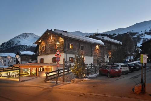 a large wooden building with cars parked in a parking lot at Chalet Matteo in Livigno