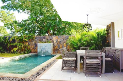 a patio with a table and chairs and a swimming pool at Luxury Villas at Royal Park in Balaclava