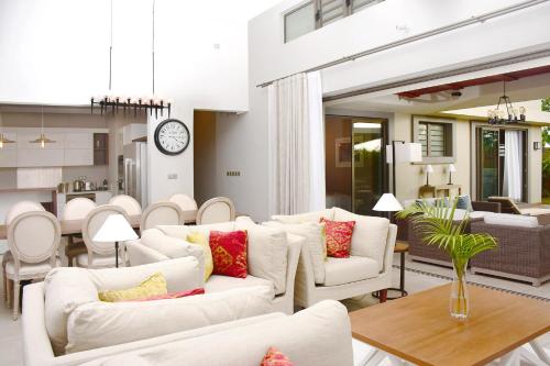 a living room with white couches and a clock at Luxury Villas at Royal Park in Balaclava