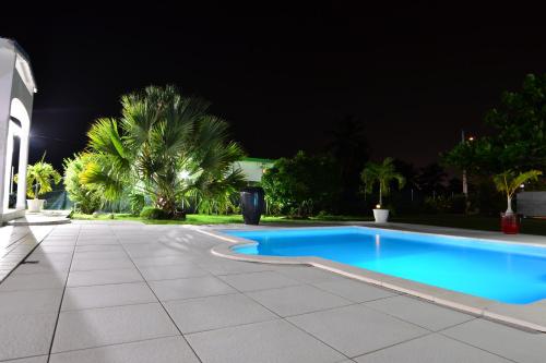 a swimming pool in a yard at night at Villa Lawrencia in Morne-à-lʼEau