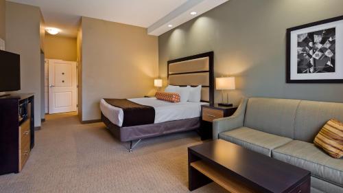 a hotel room with a bed and a couch at Best Western Plus College Park Hotel in College Park