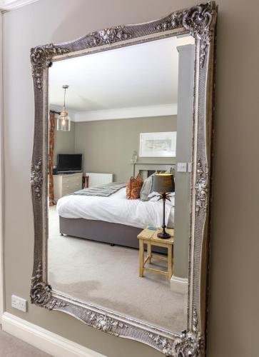 a large mirror in a bedroom with a bed at Trewornan Manor in Wadebridge