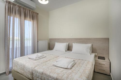 a bedroom with a large bed with two towels on it at Villa Lunea in Kalamaki Chanion
