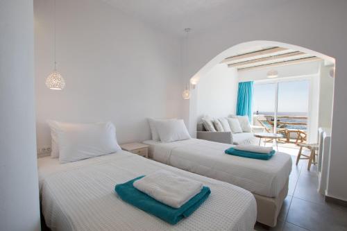 two beds in a room with a view of the ocean at Poseidon Blue Gastronomy Hotel in Afiartis