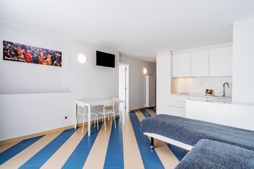 a room with two beds and a table and a kitchen at Apartamentos Sunway Amapola in Sitges