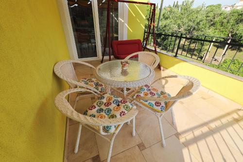 a glass table and chairs on a balcony at Senkini Dvori in Sutomišćica
