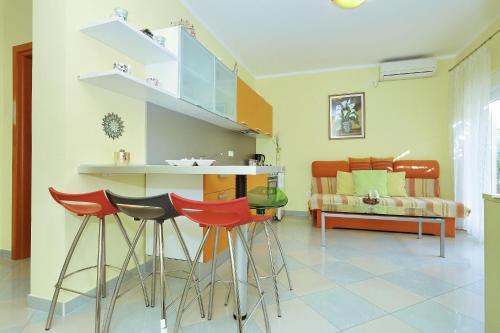 a kitchen with a bar with stools and a couch at Senkini Dvori in Sutomišćica