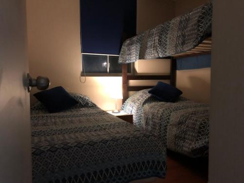 a bedroom with two beds and a bunk bed at Vista Laguna Apartment in Algarrobo