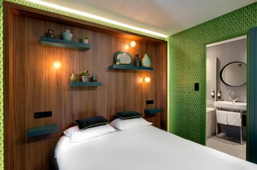 a bedroom with a white bed and a bathroom at Hôtel Montmorency & Spa in Carcassonne