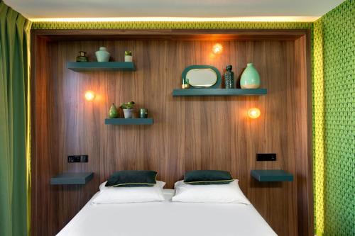 a bedroom with two beds on a wooden wall with shelves at Hôtel Montmorency & Spa in Carcassonne