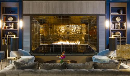a living room with a couch and a fireplace at Hotel AMO by AMANO Friedrichstraße in Berlin