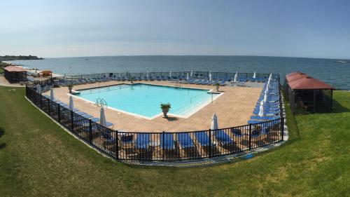 une grande piscine avec des chaises et l'océan dans l'établissement Waters Edge Resort and Spa TimeShare, à Westbrook