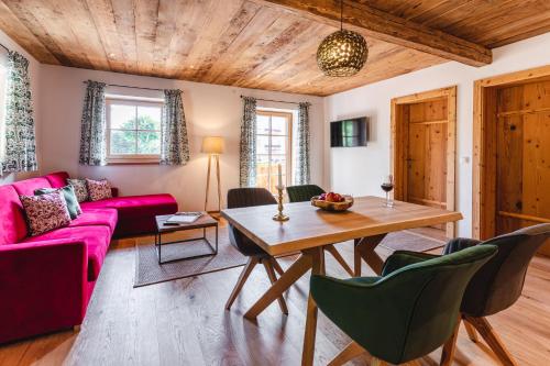 a living room with a pink couch and a table at Appartementhaus Plainstöckl Hotel Gasthof Maria Plain in Salzburg