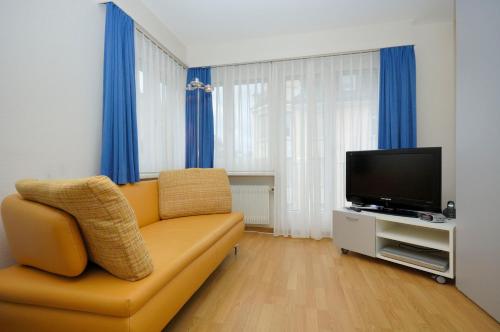 een woonkamer met een bank en een flatscreen-tv bij PABS Résidences - Kronenstrasse 37 (36) in Zürich
