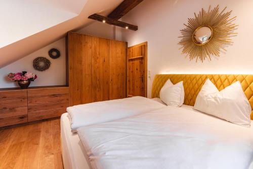 a bedroom with a large white bed and a mirror at Appartementhaus Plainstöckl Hotel Gasthof Maria Plain in Salzburg
