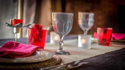 a table with two wine glasses and red candles at Lyon Campagne in Rontalon