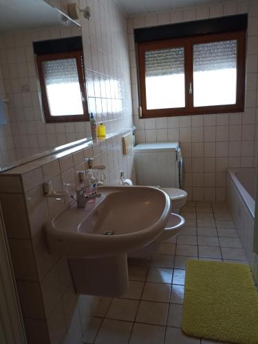 e bagno con lavandino, servizi igienici e vasca. di Ferienwohnung mit Aussicht a Eberbach