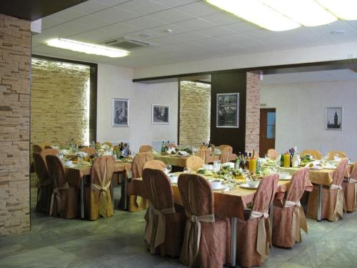 jadalnia z długimi stołami i krzesłami w obiekcie Lovech Hotel w mieście Riazań
