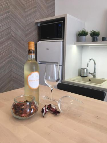 a bottle of wine and a glass on a table at Visit Debrecen Apartman in Debrecen