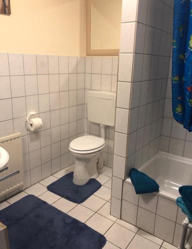 a bathroom with a toilet and a bath tub at Haus Friesenjungs in Böhl
