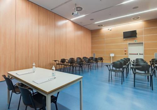 a conference room with tables and chairs and a tv at Camplus Turro Casa per Ferie in Milan